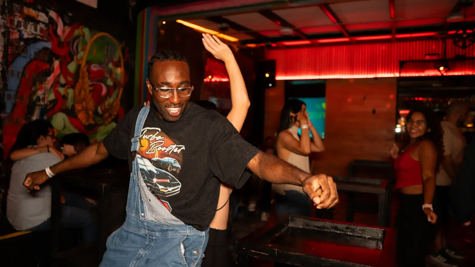 A guest dancing under red club lighting