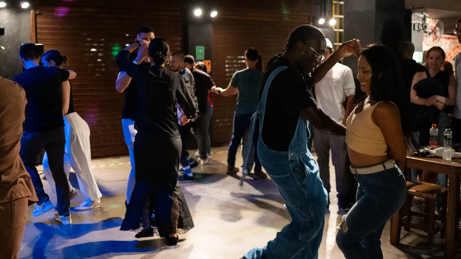 A couple dancing salsa on a crowded dance floor